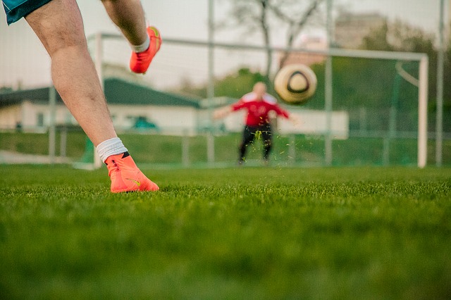 Ein Fußballer schießt einen Ball ins Tor